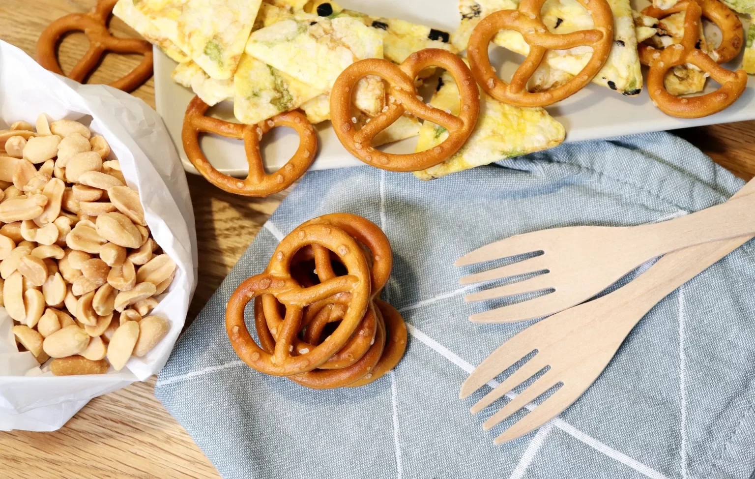 Een snackplank met noten, pretzels en knapperige hapjes voor een eenvoudig tussendoortje.