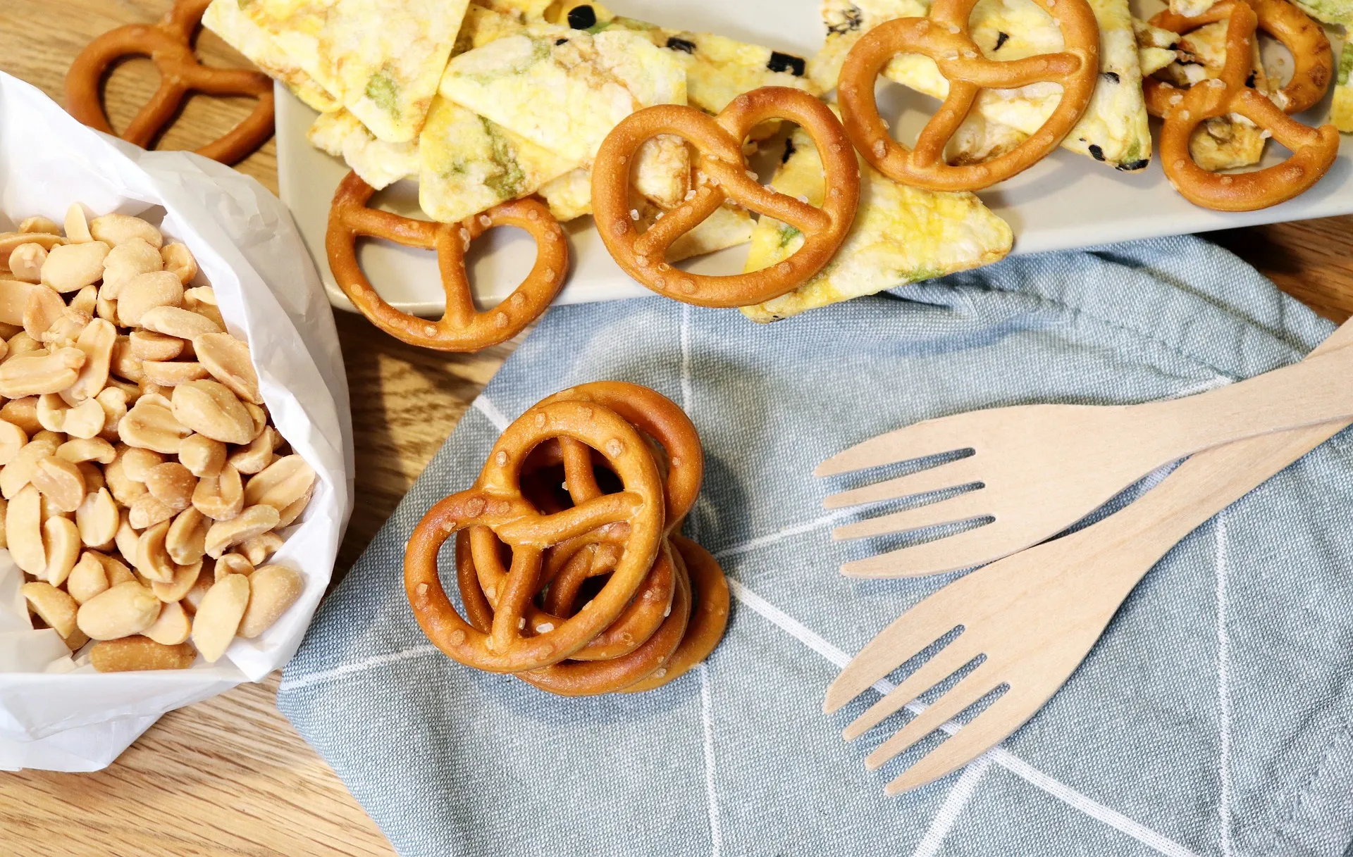 Een snackplank met noten, pretzels en knapperige hapjes voor een eenvoudig tussendoortje.