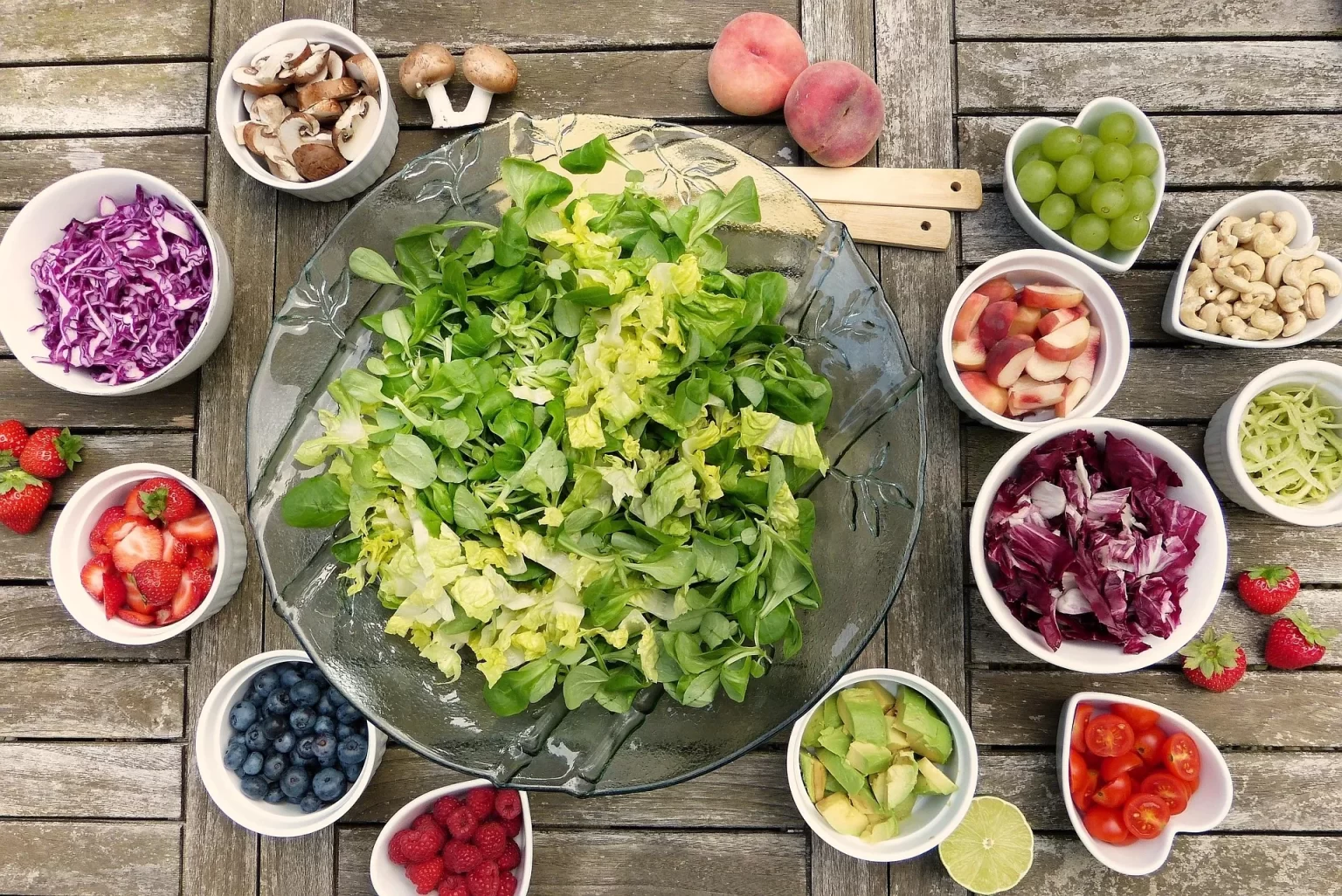 Een kleurrijke salade met bladgroenten, fruit, avocado en noten als frisse vezelrijke vegetarische maaltijd.