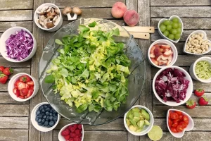 Een kleurrijke salade met bladgroenten, fruit, avocado en noten als frisse vezelrijke vegetarische maaltijd.