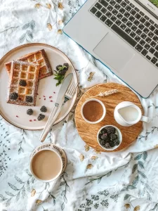 Ontbijt met wafels, bessen en koffie als inspiratie om eenvoudig meer vezels toe te voegen.