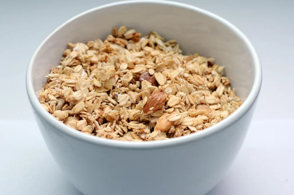 Een kom havermout met granola en noten als voedzame vezelrijke start van de dag.